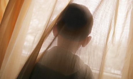 Unidentifiable child looking out of a window