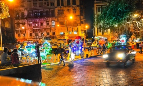 Horse-drawn carriages in Mumbai at night.