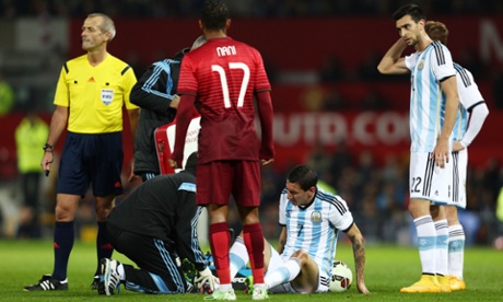Angel Di Maria sits on the Old Trafford turf with a grimace after injuring his groin in Argentina's friendly with Portugal.