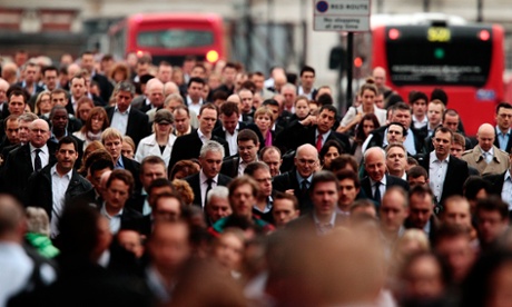 Commuters walk across London Bridge during morning rush hour