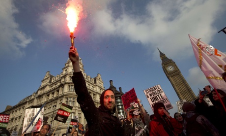 A protester holds up a lit flare during a march against student university fees.