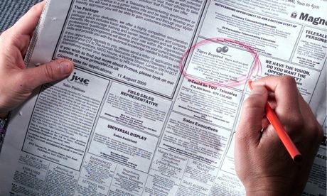 Person looking at job vacancies in a newspaper
