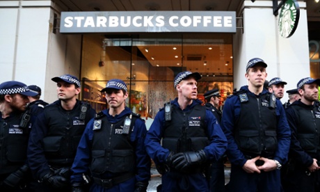 Police officers guard a Starbucks during a protest against fees.