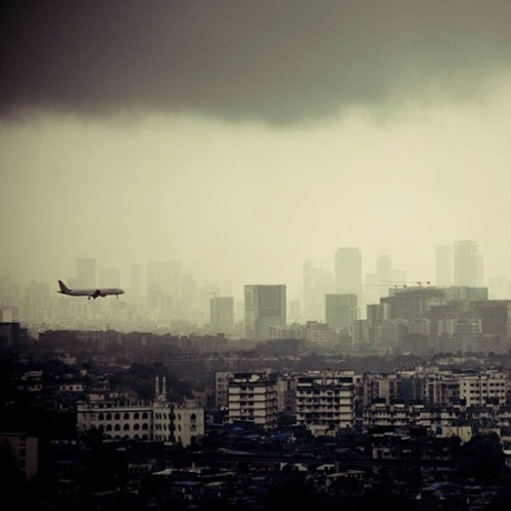 A plane lands on the runway of the Chhatrapati Shivaji International Airport amid monsoon clouds.