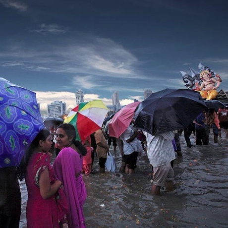 A downpour arrives during the Ganesh Visarjan festivities.