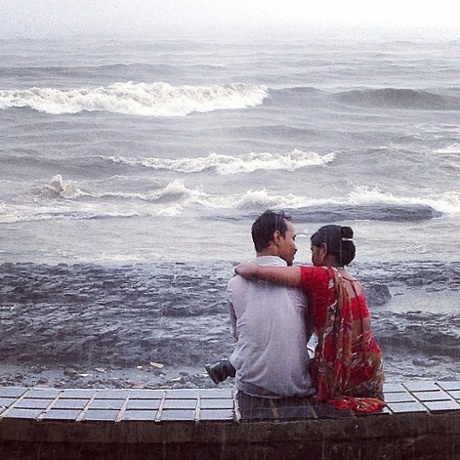 A couple sits in a monsoon.