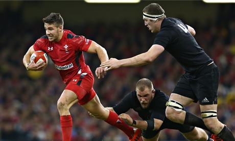 Rhys Webb of Wales bursts forward with New Zealand's Brodie Retallick in pursuit