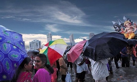 A downpour arrives during the Ganesh Visarjan festivities.