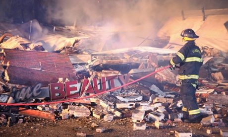 A Ferguson firefighter surveys rubble at a strip mall early Tuesday.
