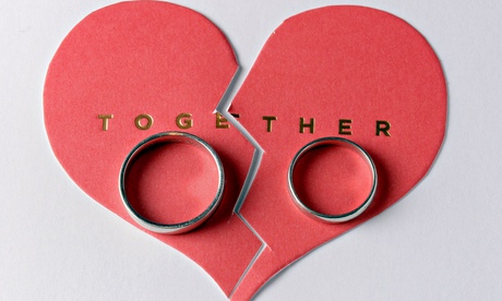 A pair of wedding rings pictured on a broken cardboard heart