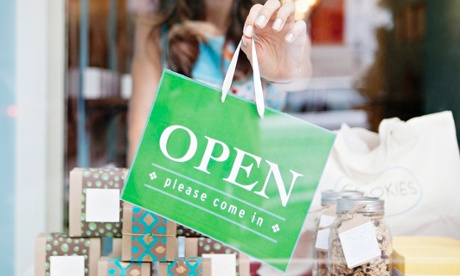 Store owner holding open sign