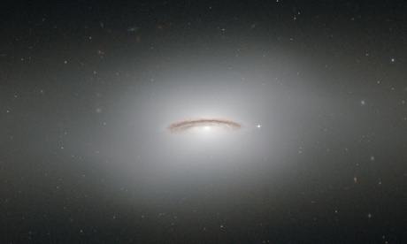 This neat little galaxy is known as NGC 4526. Its dark lanes of dust and bright diffuse glow make the galaxy appear to hang like a halo in the emptiness of space in this new image from the NASA/ESA Hubble Space Telescope.