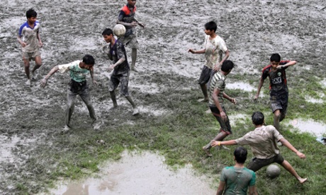 Boys play a muddy game of football in Kolkata, West Bengal.