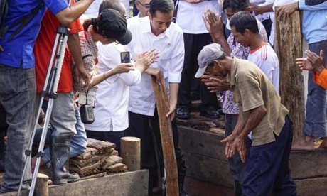 Indonesian President, Joko Widodo joins members of the Sungai Tohor community in damming a canal draining peatlands on Tebing Tinggi island. Indonesia s carbon-rich peatlands are being destroyed by the pulp and oil palm plantation industries, laying foundations for forest fires that devastate the lives of millions of people in the region.