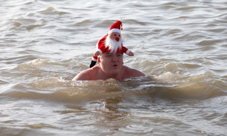 man swimming with santa hat