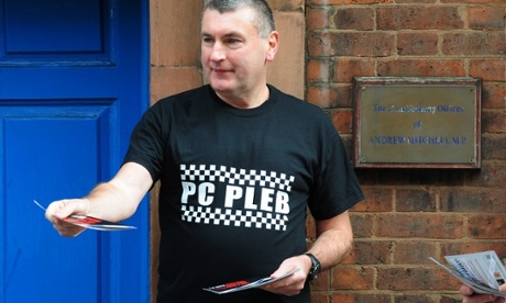 PC Mick Callaghan hands out leaflets outside the constituency offices of MP Andrew Mitchell, for the launch of a poster campaign against police cuts, in Sutton Coldfield, West Midlands.