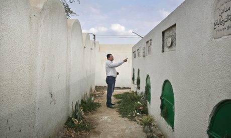 Reda el-Danbouki, the lawyer for 13-year-old Sohair al-Bata'a who died after undergoing FGM, points at her grave on the outskirts of Agga town, Egypt.