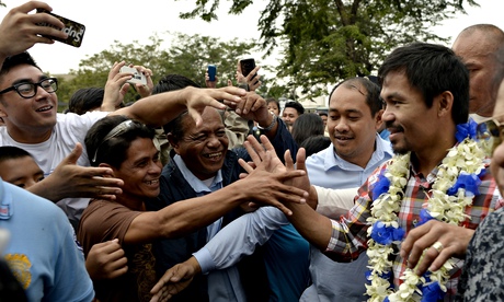 Boxer Manny Pacquiao greets fans during his victory parade in Manila