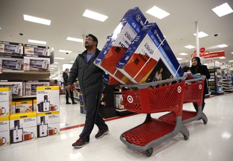 Ahmad Ali and his wife, Ghalzal, of Portland, Maine, look to get in line to pay for three flat-screen televisions while shopping at a Target store just after midnight on Black Friday.