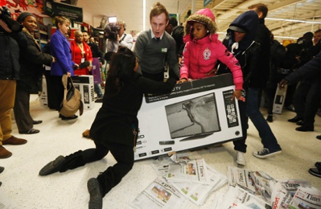 Shoppers wrestle over a television as they compete to purchase retail items on 