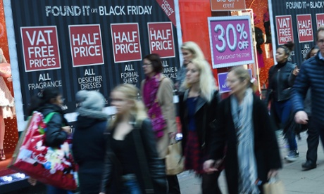 Shoppers pass a store offering Black Friday sales on Oxford Street in London.