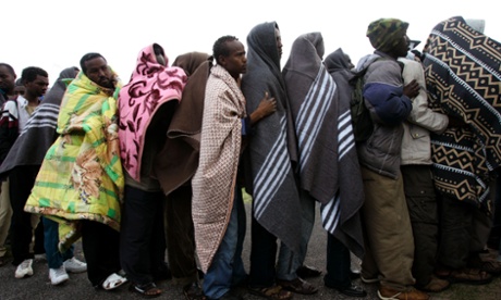 Somali and other refugees stand in line for food at a makeshift camp near the small town of Scarborough, South Africa.