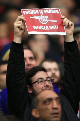 A Arsenal fan holds up a sign in the stands which reads 'Enough is Enough Wenger Out' during the Barclays Premier League match at The Hawthorns, West Bromwich. PRESS ASSOCIATION Photo. Picture date: Saturday November 29, 2014. See PA story SOCCER West Brom. Photo credit should read Mike Egerton/PA Wire. Editorial use only. Maximum 45 images during a match. No video emulation or promotion as 'live'. No use in games, competitions, merchandise, betting or single club/player services. No use with unofficial audio, video, data, fixtures or club/league logos.sign signage half mid length