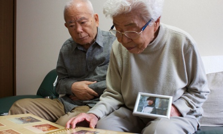 Akihiro and Kayoko Arimoto look at old photographs of their daughter, Keiko