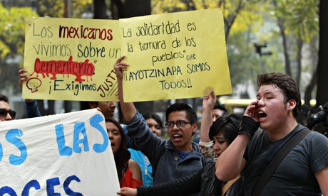 Protesters call for justice after the mayor's detention. The signs read 'Mexicans live on a cemetery