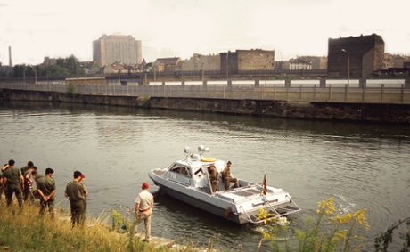 British soldiers install a swimming pool-style ladder in the bank of the river which marked the border between east and west to help people who swam the river to escape the East. After a few minutes an East German patrol boat started roaring up and down the river attempting to soak the soldiers. August 1989
