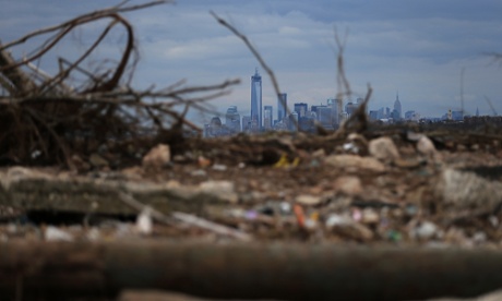 Debris sits on a still-closed Staten Island beach area damaged by flooding from hurricane Sandy, with Lower Manhattan and One World Trade Center in the background.