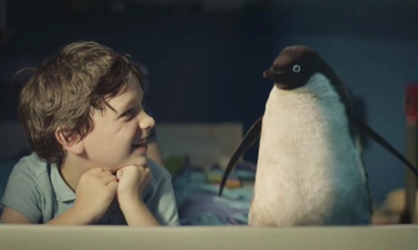 A young boy and a penguin, in a room, yesterday.