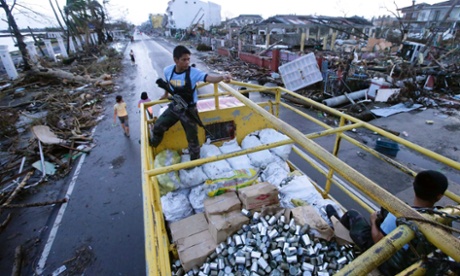 Filipino policemen in Tacloban secure a truckload of relief goods following typhoon Haiyan