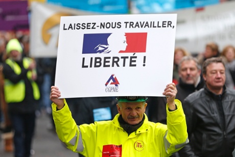 Heads of small and mid-size French companies attend a demonstration organized by the French CGPME (Confederation of Small and Medium Sized Enterprises) employers groups to protest against government policy and what they see as excessive restrictions and charges in Paris December 1, 2014. Sign reads, 