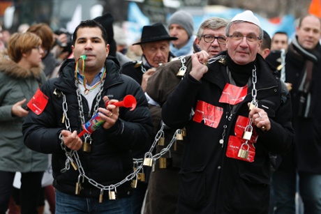 Locks and chains are held by a people who participate in the protest march by the heads of small and mid-size French companies in Paris December 1, 2014. People  attend a demonstration organized by the French CGPME (Confederation of Small and Medium Sized Enterprises) employers groups with locks and chains symbolizing their protest against government policy and what they see as excessive restrictions and charges.