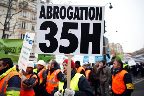 Heads of small and mid-size French companies attend a demonstration organized by the French CGPME (Confederation of Small and Medium Sized Enterprises) employers groups to protest against government policy and what they see as excessive restrictions and charges in Paris December 1, 2014. Sign reads, 