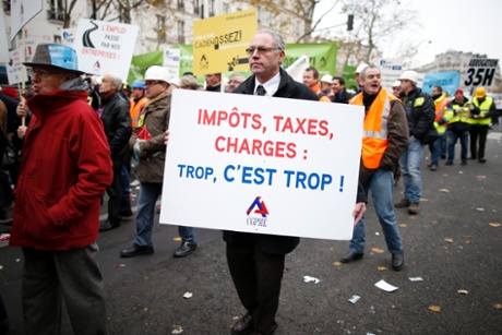 Heads of small and mid-size French companies attend a demonstration organized by the French CGPME (Confederation of Small and Medium Sized Enterprises) employers groups to protest against government policy and what they see as excessive restrictions and charges in Paris December 1, 2014. Sign reads, 
