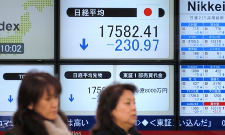 Pedestrians walk past a share prices board illustrating the numbers on the Tokyo Stock Exchange in Tokyo on December 10, 2014.