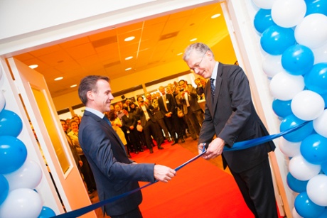 Two people cutting a ribbon to open a healthcare refurbishment systems factory