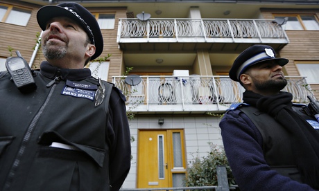 Police stand guard at a property in Brixton