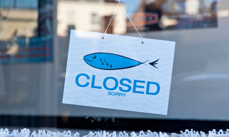 Closed sign in a fish and chip shop window.