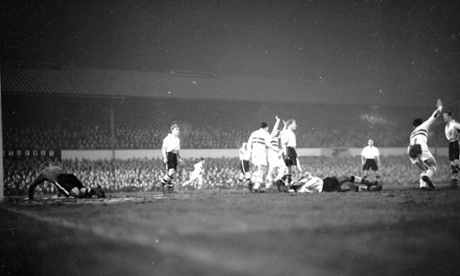 Honved players, in striped shirts, celebrate after Kocsis scored their first goal against Wolverhampton Wanderers, in Wolverhampton, Dec. 14, 1954. At right is Wolves goalkeeper Williams, on gorund, and Wolves captain Billy Wright, standing. Wolves, top team in the English soccer league, defeated Honved, top team in the Hungarian league, 3-2 in this flood-lit match. (AP Photos)