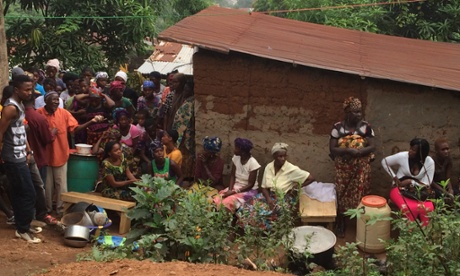 Family and friends of a man who died of suspected Ebola gather outside his house