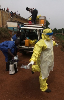 One of the burial team is sprayed with chlorine solution before removing his protective suit