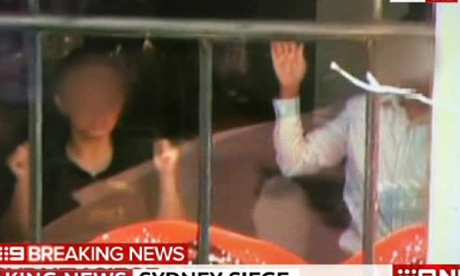 Hostages holding their arms in the air at the Lindt Chocolate Cafe in Macquarie Street. 