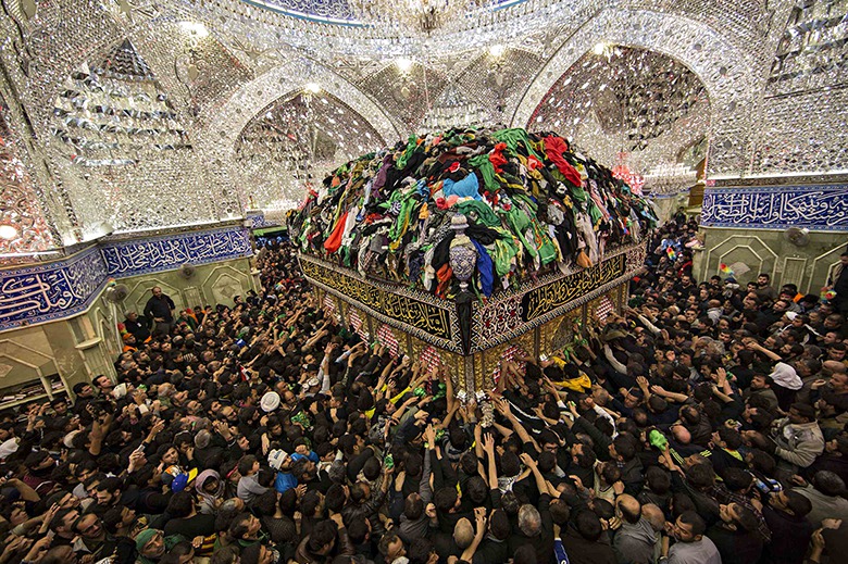 Shia Muslim pilgrims reach out to touch the tomb of Imam Kerbala al-Abbas in Kerbala