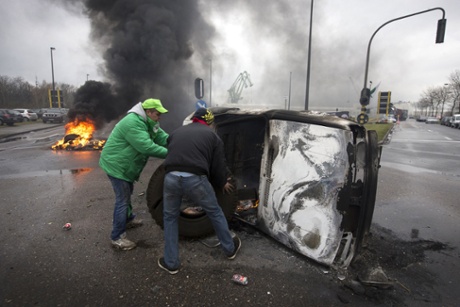 Belgian trade union members burn a car at the Port of Antwerp during a nationwide general strike in Brussels on December 15, 2014.