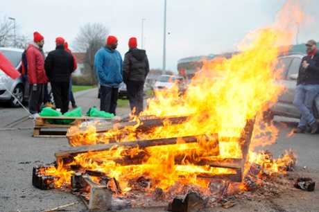 Workers and members of trade unions block a road leading to a Brussels airport catering company during a national strike in a protest over the government's planned pension reform and budget cuts at the Brussels Airport in Zaventem.