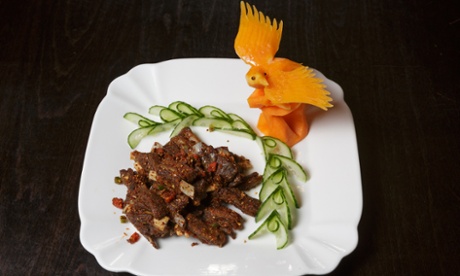 Lamb ribs with cumin artfully arranged with a bird carved from food