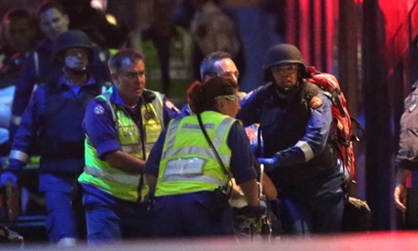 Emergency personnel wheel an injured hostage to an ambulance.